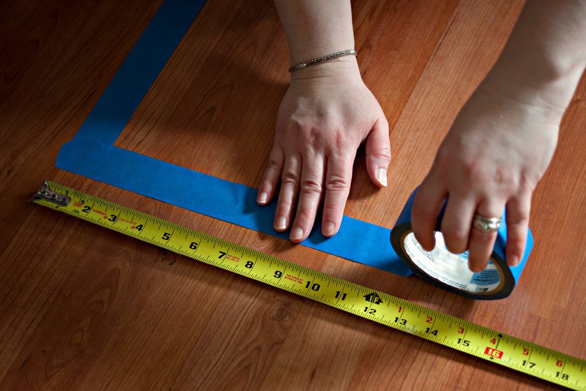 Tape measure stretched across the floor of an empty room in a house, checking the living area against the county property record