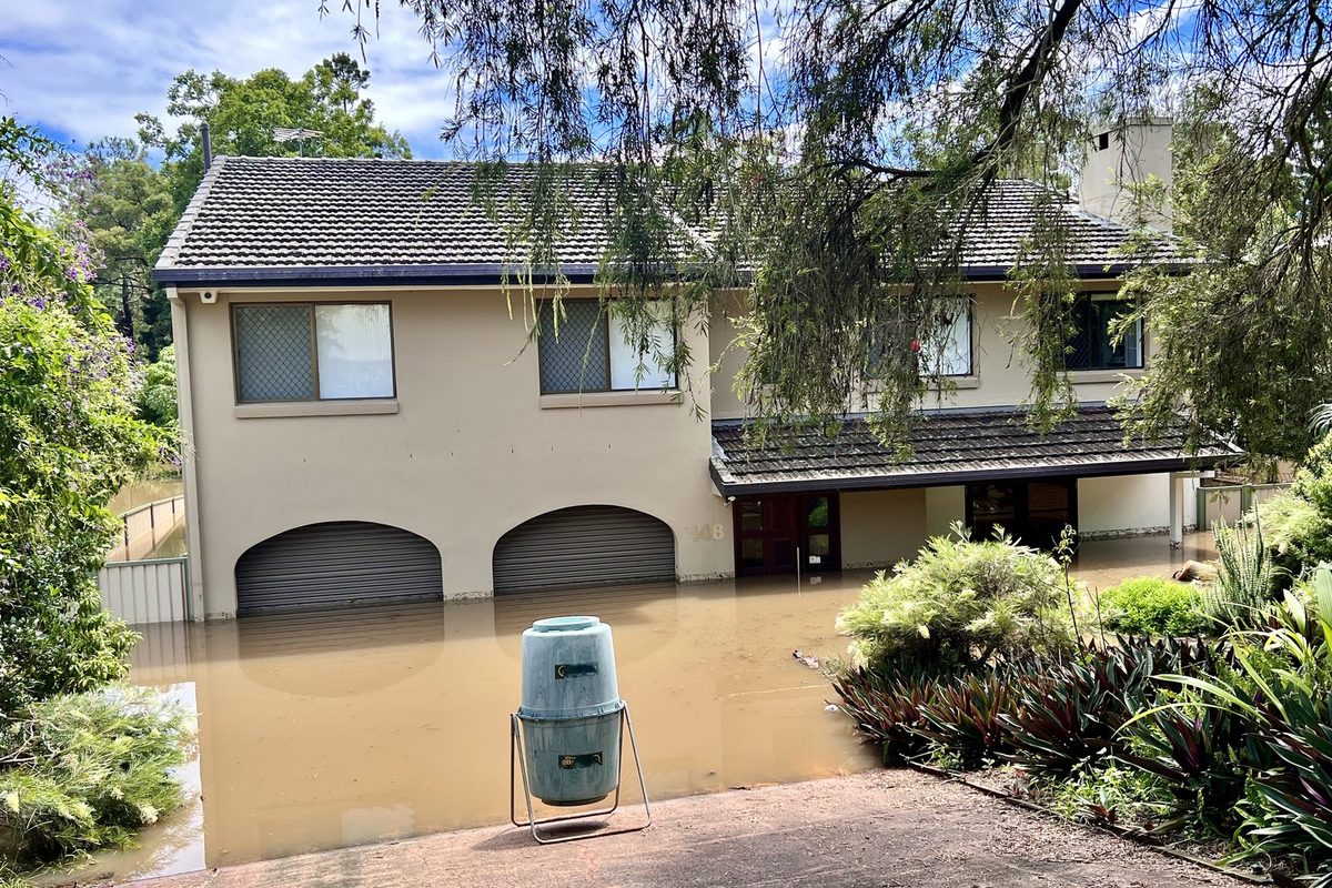 Flooded residential street with houses standing in water, the scenario a flood zone by address check is meant to anticipate