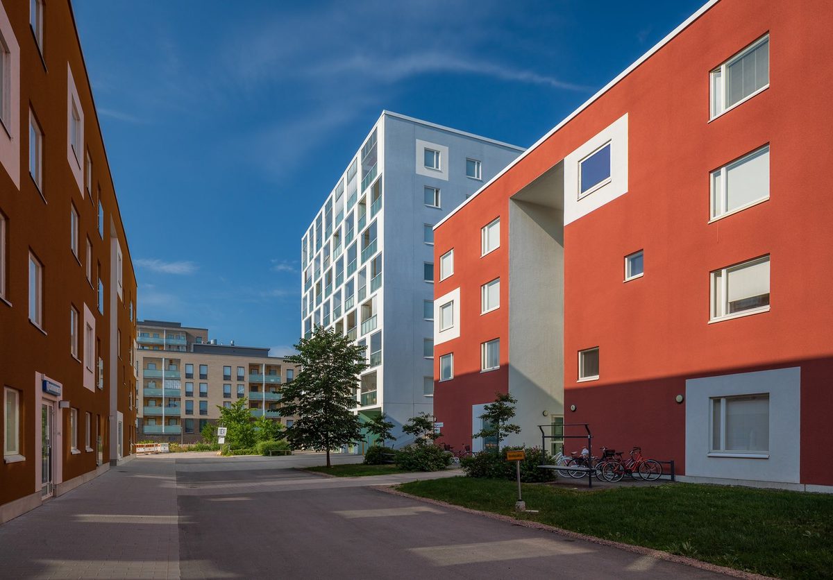 Row of small apartment buildings and single-family rentals on a city street, the mixed portfolio a landlord revalues each year