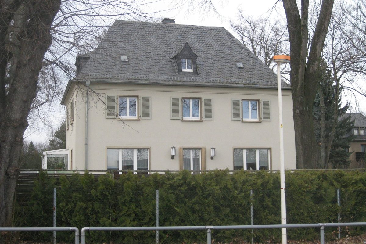 Schlüsselübergabe vor einem Einfamilienhaus am Ende eines Hauskaufs, nach Kaufvertrag, Treuhandzahlung und Grundbucheintragung