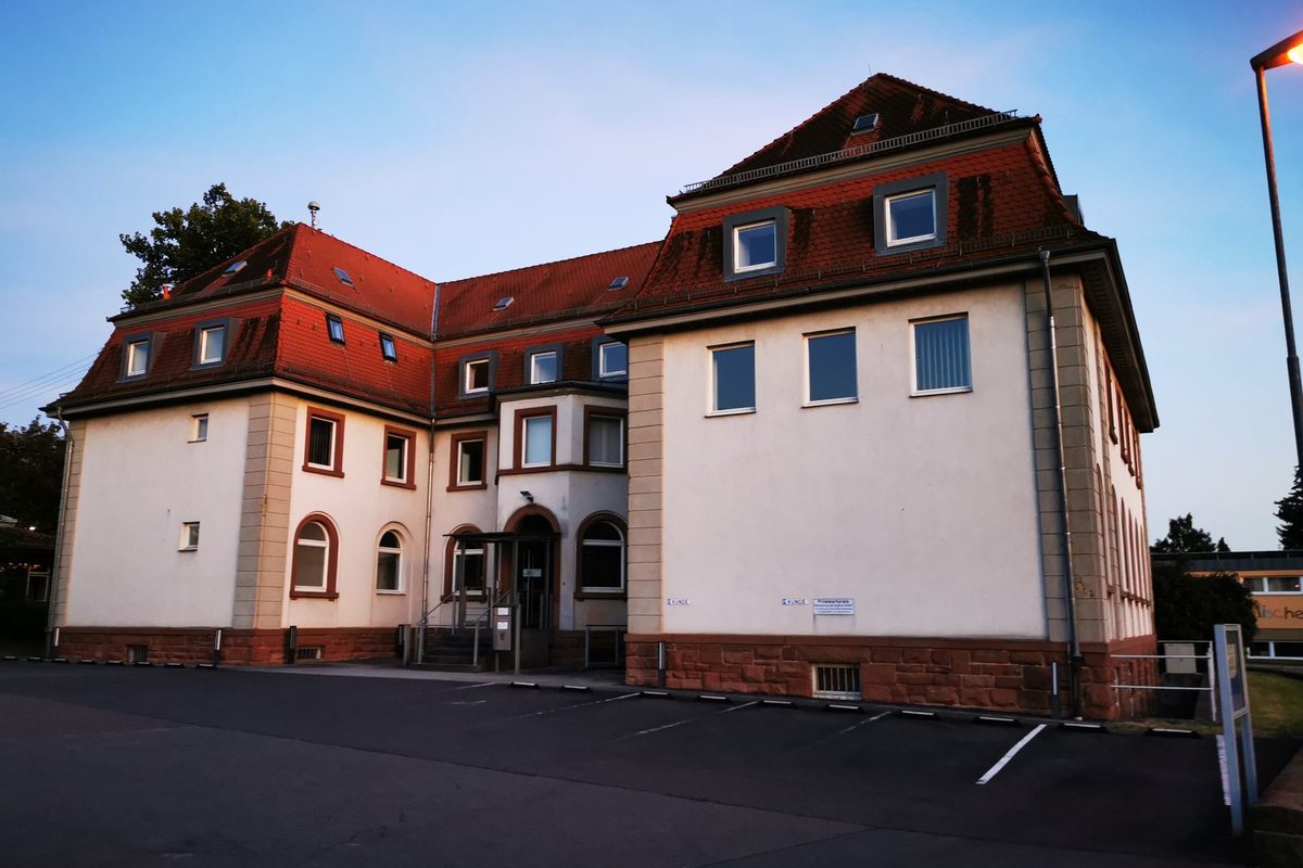 Eigentümerin am Esstisch mit Laptop, Grundbuchsauszug und Energieausweis beim Vergleich kostenloser Immobilienbewertungen