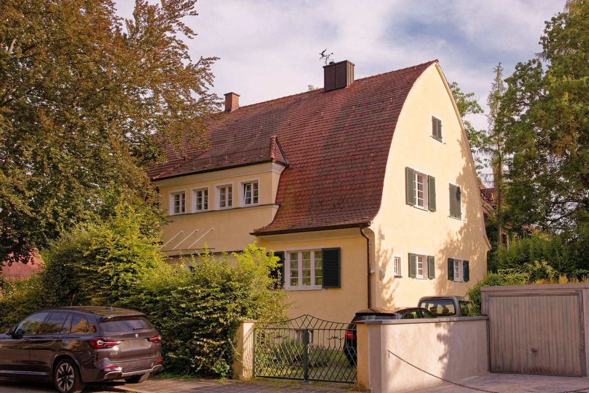 Verkaufsschild vor einem Einfamilienhaus mit überklebter Preisangabe, Sinnbild für den teuersten Fehler beim Hausverkauf