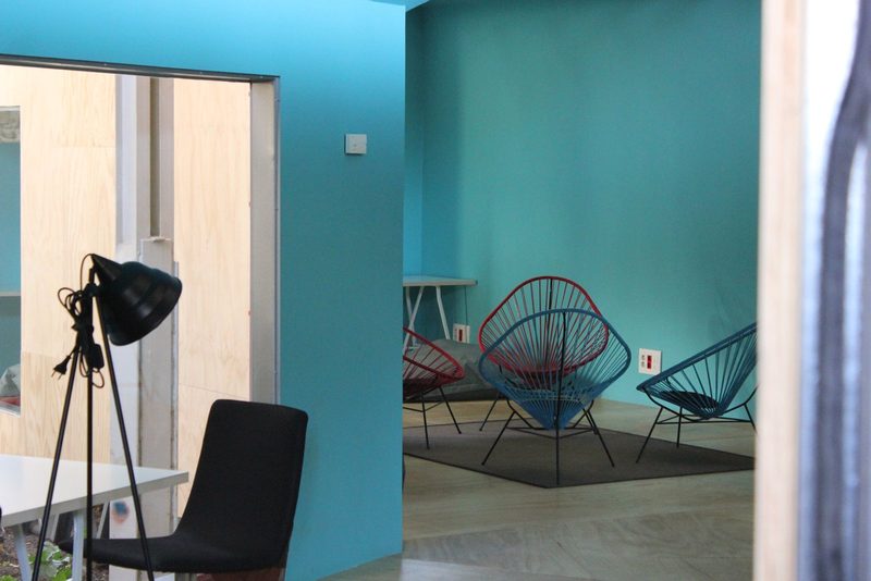 Interior de una vivienda en Madrid con paredes turquesa, tabique de madera y sillas de rejilla, el tipo de estancia que inspecciona un tasador