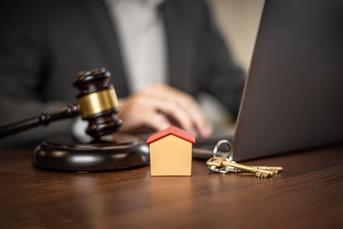 Clés de maison posées sur des documents de vente et une calculatrice, le dossier que réunit un propriétaire avant de vendre