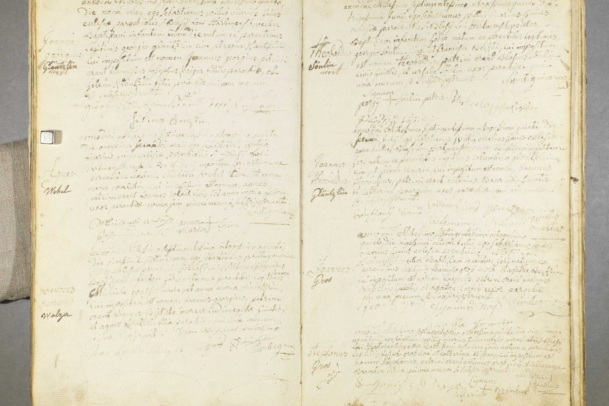 Registre paroissial manuscrit de 1785 ouvert sur deux pages, actes en latin et noms inscrits en marge, conservé aux archives départementales
