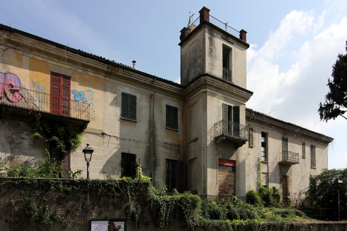 Palazzo Rovelli a Cogliate, in Lombardia: facciata con intonaco scrostato, persiane chiuse e balconi in ferro battuto, immobile storico da valutare